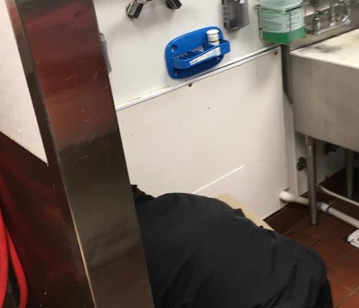 SERVPRO employee  under utilty sink