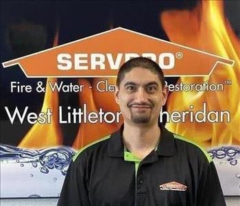 Male employee smiling in front of an orange background