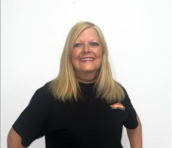 Female employee with blonde hair smiling in from of an white background