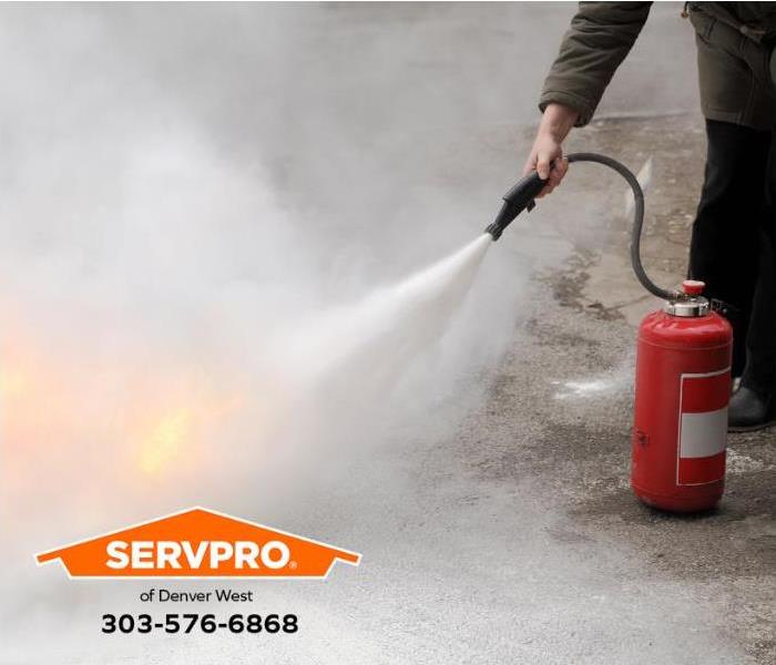 A person is using a portable fire extinguisher. 